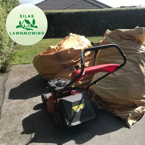 Mower and bags of green waste on a driveway ready for removal in Glen Eden