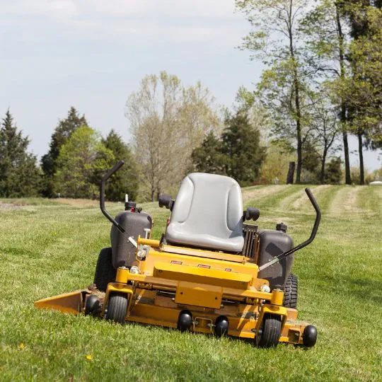 Ride-on mower on a large striped lawn in West Auckland